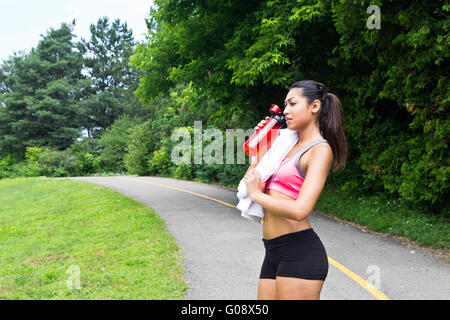 Donna Bevande Acqua e riposa dopo aver eseguito Foto Stock