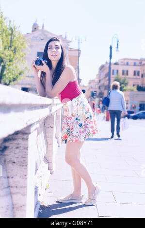 Giovane donna turistica prendendo foto all'aperto con fotocamera vintage Foto Stock