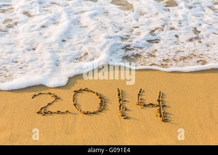 Anno Nuovo 2014 è venuta concetto. Iscrizione 2014 sulla spiaggia di sabbia. Foto Stock