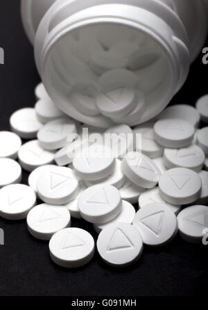 Capsule fuoriuscito dalla bottiglia bianca Foto Stock