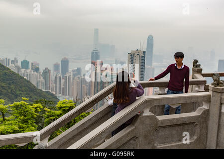 Turisti che si godono il Victoria Peak lookout in Hong Kong Foto Stock