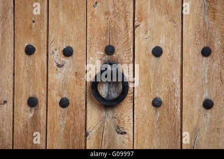 La maniglia di una porta o kncker su una vecchia porta di legno Foto Stock