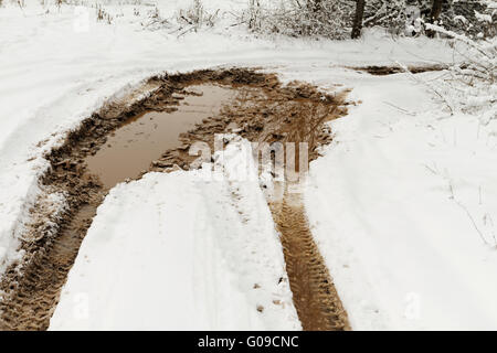 Tracce dalle ruote della macchina su terreni fangosi neve Foto Stock