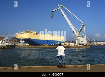 Il pescatore nel bacino portuale di Durban, Sud Africa Foto Stock