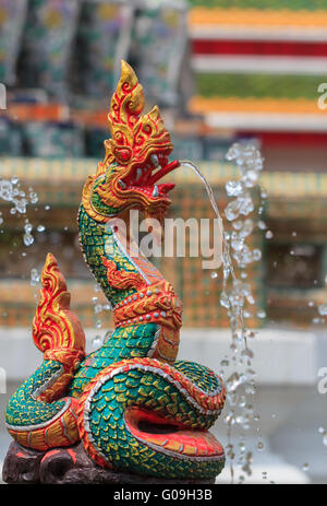 Naga Thai statua spruzzare acqua in sfondo sfocato Foto Stock