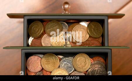 Stash di monete tenute in Disegna gioielli home concetto di risparmio. Foto Stock