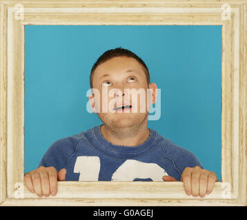 Giovane uomo dentro il telaio in legno Foto Stock