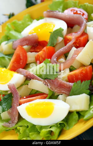 Insalata con le uova, pomodorini e acciughe. Foto Stock