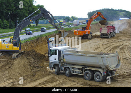 Camion e scavatori alla costruzione di strada in Germania Foto Stock