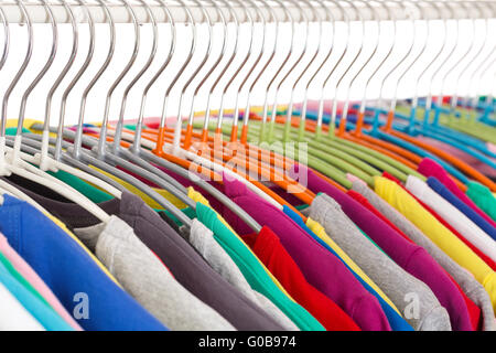 Collezione di magliette colorate sulle staffe in acciaio Foto Stock