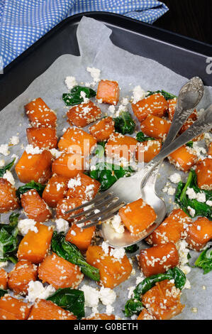 Fette di zucca al forno con spinaci e semi di sesamo su una placca da forno Foto Stock