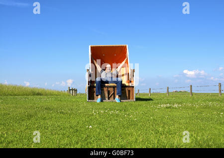 Uomo sulla sedia spiaggia Foto Stock