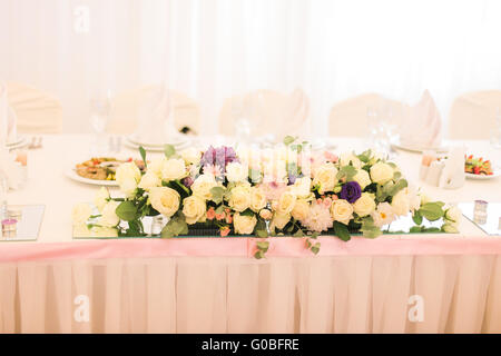 Elegantemente decorate con fiori di colore bianco, bicchieri e candele ristorante per celebrare matrimoni Foto Stock