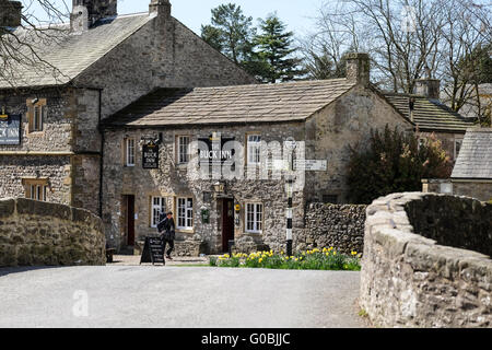 Un viandante passa il Buck Inn a Malham nel Yorkshire Dales Foto Stock