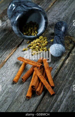 Still-life di spezie e di mortaio su una tavola di legno Foto Stock