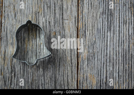 Campana di Natale cookie cutter in legno rustico sfondo Foto Stock