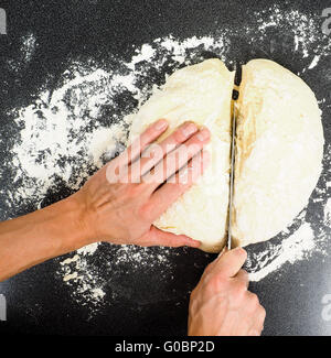 Mani il taglio di uno spezzone di pasta Foto Stock