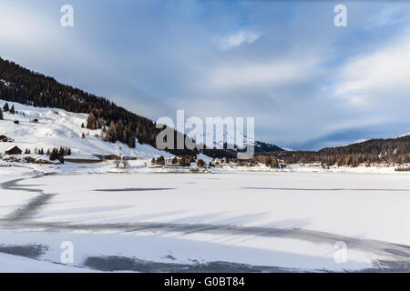 Vista panoramica del surgelato, Lago di Davos, il villaggio di Davos e le Alpi in inverno del Cantone dei Grigioni, Svizzera Foto Stock