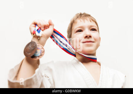 Sorridente campione del karate bambino ragazzo gesticolando per vi Foto Stock