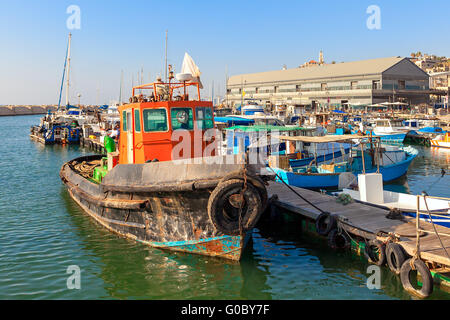 E colorata antica ruggine fisherman barca legato ad un molo nel porto della vecchia Jaffa in Israele. Foto Stock