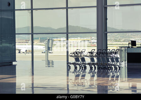 Sala di attesa dell'aeroporto El Prat di Barcellona con bagagli vuoti carrelli fila Foto Stock