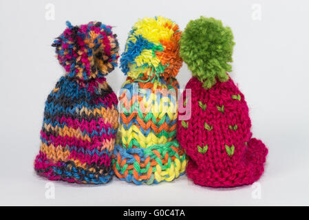 Tre piccoli lavorati a maglia bobble caps Foto Stock