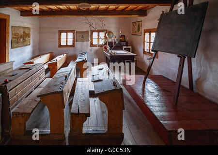Antica aula tradizionale con panche di legno e ardesia compresse Foto Stock