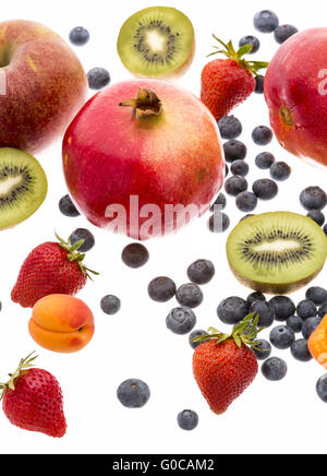 Varietà di frutta sparse su sfondo bianco Foto Stock