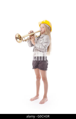 Ragazza giovane con casco giallo suona la tromba in studio contro uno sfondo bianco Foto Stock