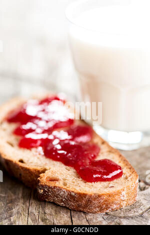 Pane con diffusione di fragola e bicchiere di latte Foto Stock