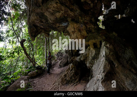 Un uomo locale immettendo la Candelaria grotta naturale sistema famoso per la sua peculiare dei fenomeni carsici e significato per la storia Maya in highland-pianura transizione di Alta Verapaz tra i comuni di Chisec Raxruha e in Guatemala America centrale. Foto Stock