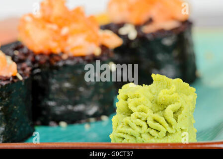 Wasabi con sushi cotto rotoli sulla piastra di turchese Foto Stock