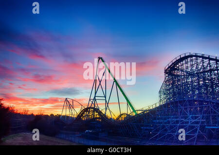 Curve di un roller coaster al tramonto o l'alba Foto Stock