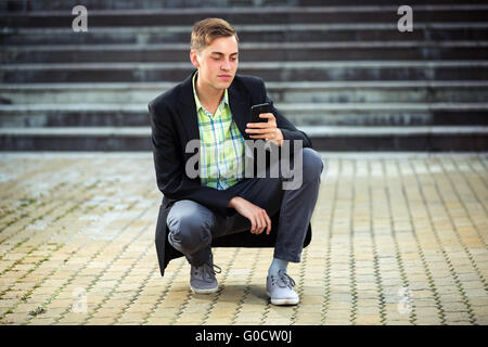 Giovane uomo chiamando al telefono cellulare all'aperto Foto Stock