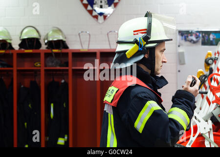 Vigile del fuoco in reparto antincendio con radio. Foto Stock