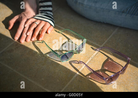 In amore giovane seduto sul pavimento tenendo le mani Foto Stock