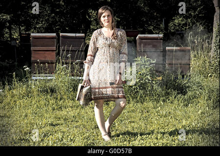 Apicoltore femmina lavorando sul suo alveari Foto Stock