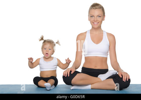 Felice mamma e figlia si impegnano nel fitness sul tappetino Foto Stock