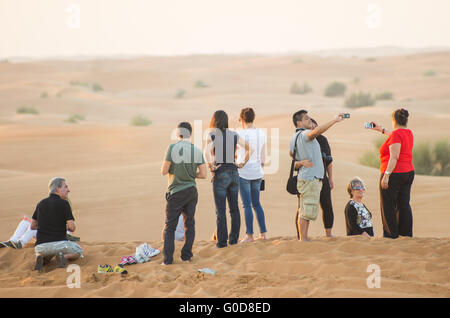 NOV 29 -Dubai, UAE: la gente a guardare il tramonto e tenendo selfies nel deserto Arabo durante un safari nel deserto il 29 o Foto Stock