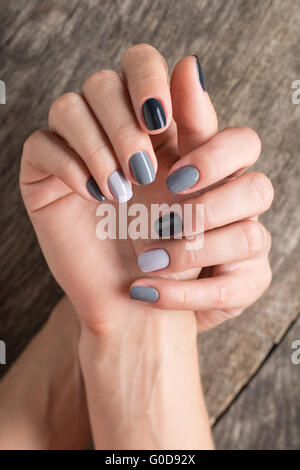 Mani belle con la miniatura dipinto in un colore grigio-smalto colorato Foto Stock