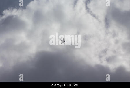 Un velivolo vola al di sotto di nubi in avvicinamento per l'atterraggio all' Aeroporto di Heathrow di Londra, Regno Unito Foto Stock