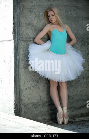 Leggiadra danzatrice con capelli biondi sullo sfondo di grigio concre Foto Stock