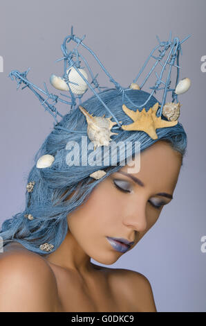 Donna attraente con capelli blu, corona e conchiglie Foto Stock