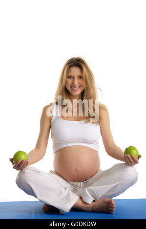 Donna incinta a praticare yoga e mantiene le mele Foto Stock