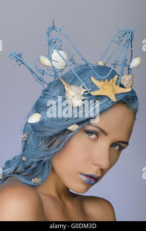 Giovane donna con capelli blu, corona e conchiglie Foto Stock