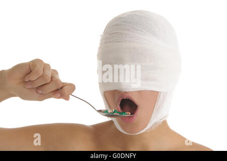 Giovane donna con la testa fasciata accetta la medicina Foto Stock