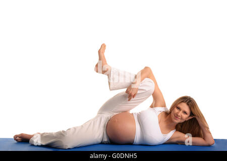 Donna incinta sdraiato e la pratica dello yoga Foto Stock