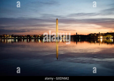 WASHINGTON, D.C., Stati Uniti — il Washington Monument si erge alto contro un vibrante cielo prealba in una tranquilla mattina di primavera a Washington, D.C. l'iconico obelisco, centrato nella cornice, è sagomato drammaticamente contro le colorate sfumature della luce del mattino presto, creando una scena mozzafiato nella capitale della nazione. Foto Stock