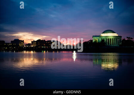 Jefferson Memorial at Sunrise Washington D.C. // WASHINGTON, D.C., Stati Uniti - il Jefferson Memorial si erge maestosamente contro un vibrante cielo prealba a Washington, D.C. la silhouette distintiva del monumento neoclassico contrasta drammaticamente con le sfumature colorate della mattina presto, creando una scena mozzafiato presso il bacino delle maree. Foto Stock