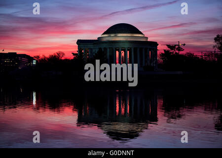 Jefferson Memorial at Sunrise Washington D.C. // WASHINGTON, D.C., Stati Uniti - il Jefferson Memorial si erge maestosamente contro un vibrante cielo prealba a Washington, D.C. la silhouette distintiva del monumento neoclassico contrasta drammaticamente con le sfumature colorate della mattina presto, creando una scena mozzafiato presso il bacino delle maree. Foto Stock